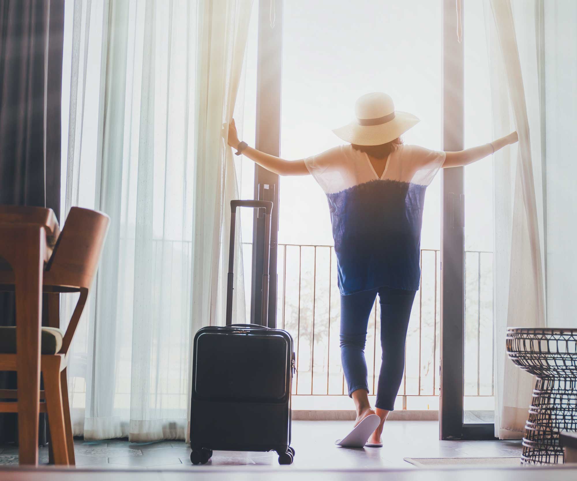 woman standing at hotel window looking out